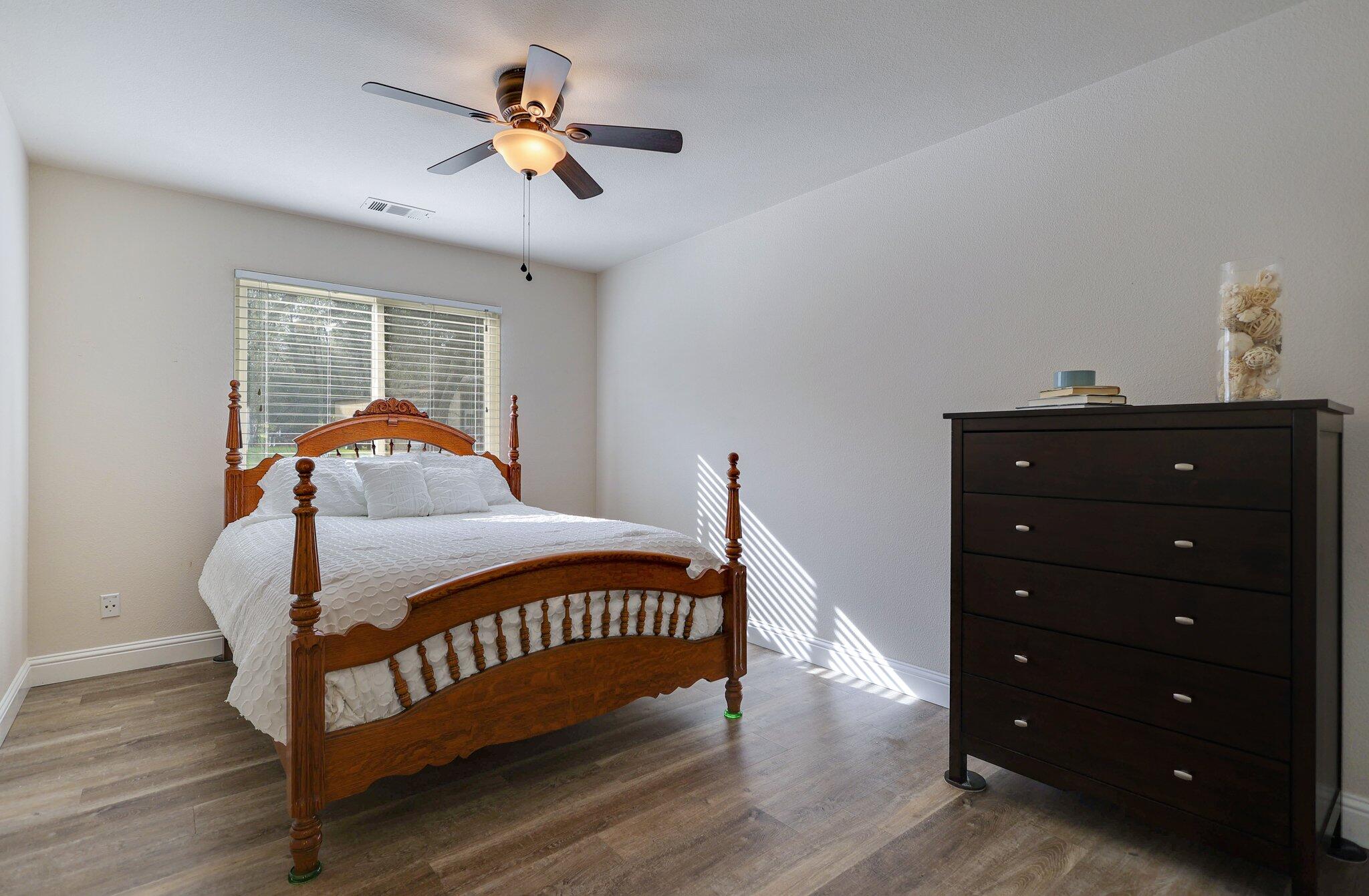 21365 Dersch Road Anderson, CA 96007 - Photo 21 of 55 a bedroom with a bed and a chandelier
