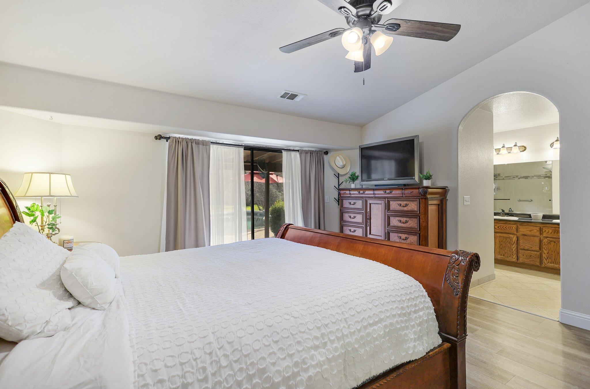 21365 Dersch Road Anderson, CA 96007 - Photo 26 of 55 a bedroom with a bed and a chandelier with a flat tv screen