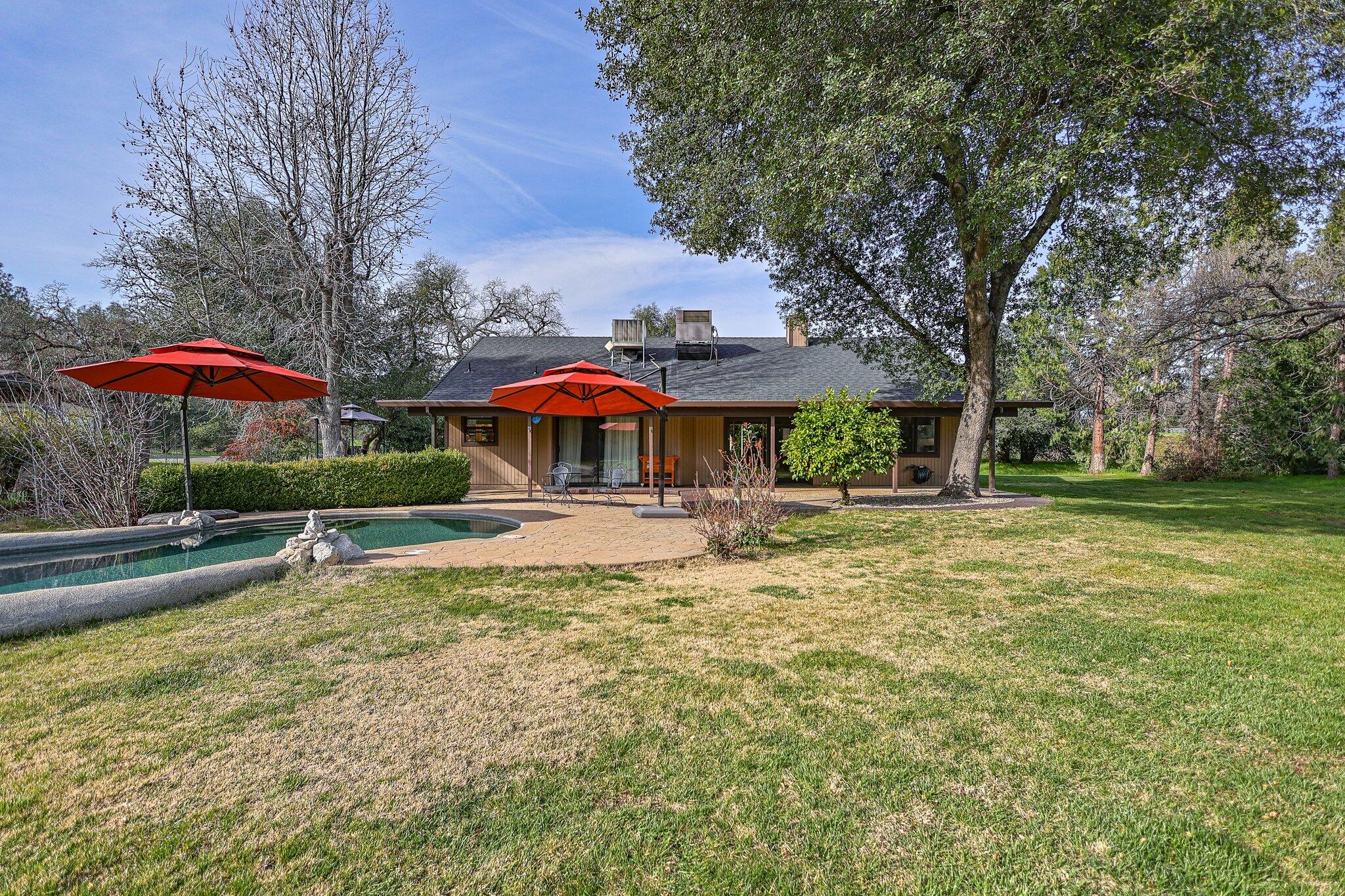 21365 Dersch Road Anderson, CA 96007 - Photo 36 of 55 a view of a swimming pool with a table and chairs under an umbrella