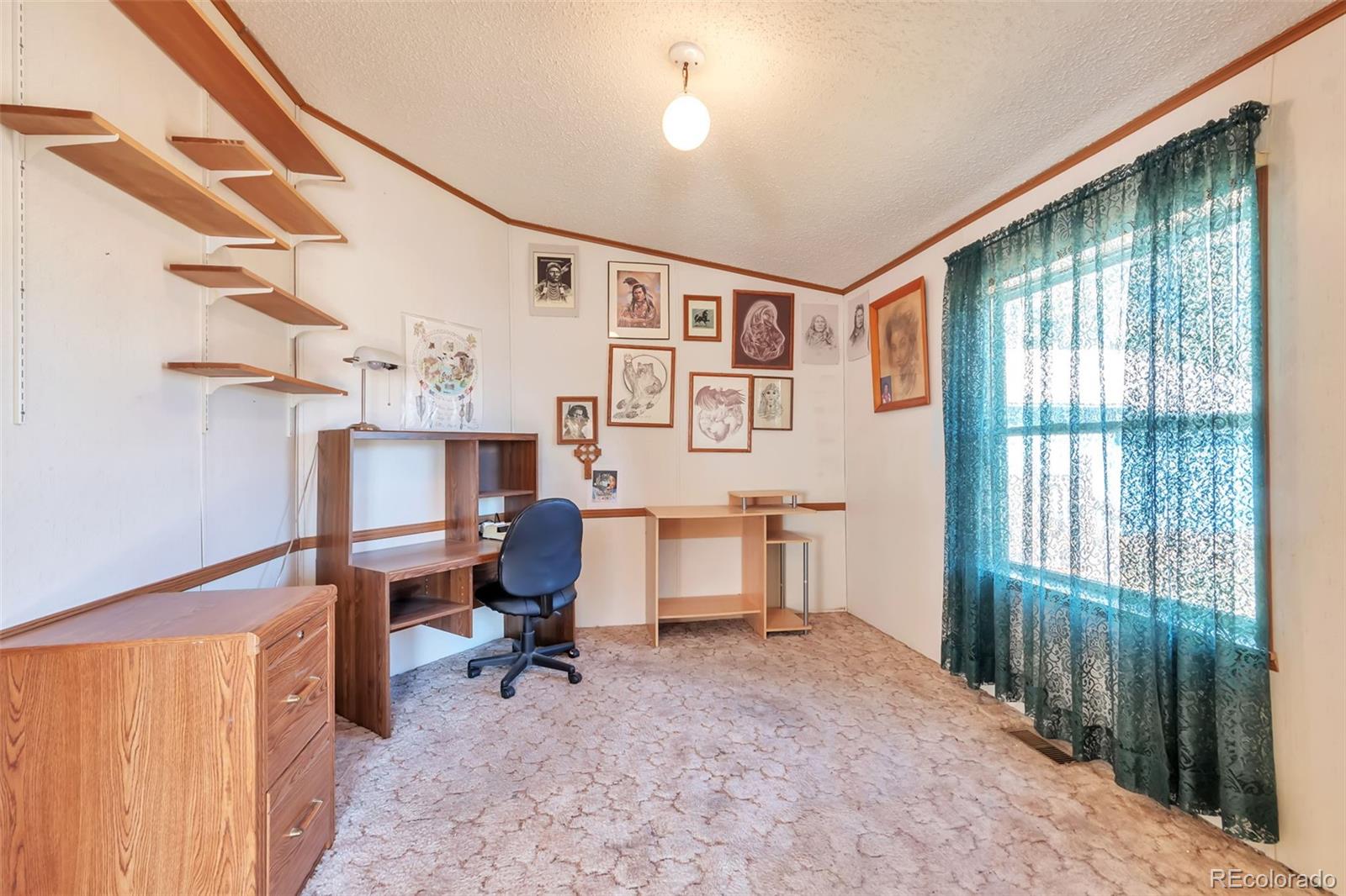 7702 Hart Street Fort Lupton, CO 80621 - Photo 11 of 25 a view of a workspace with furniture and a window