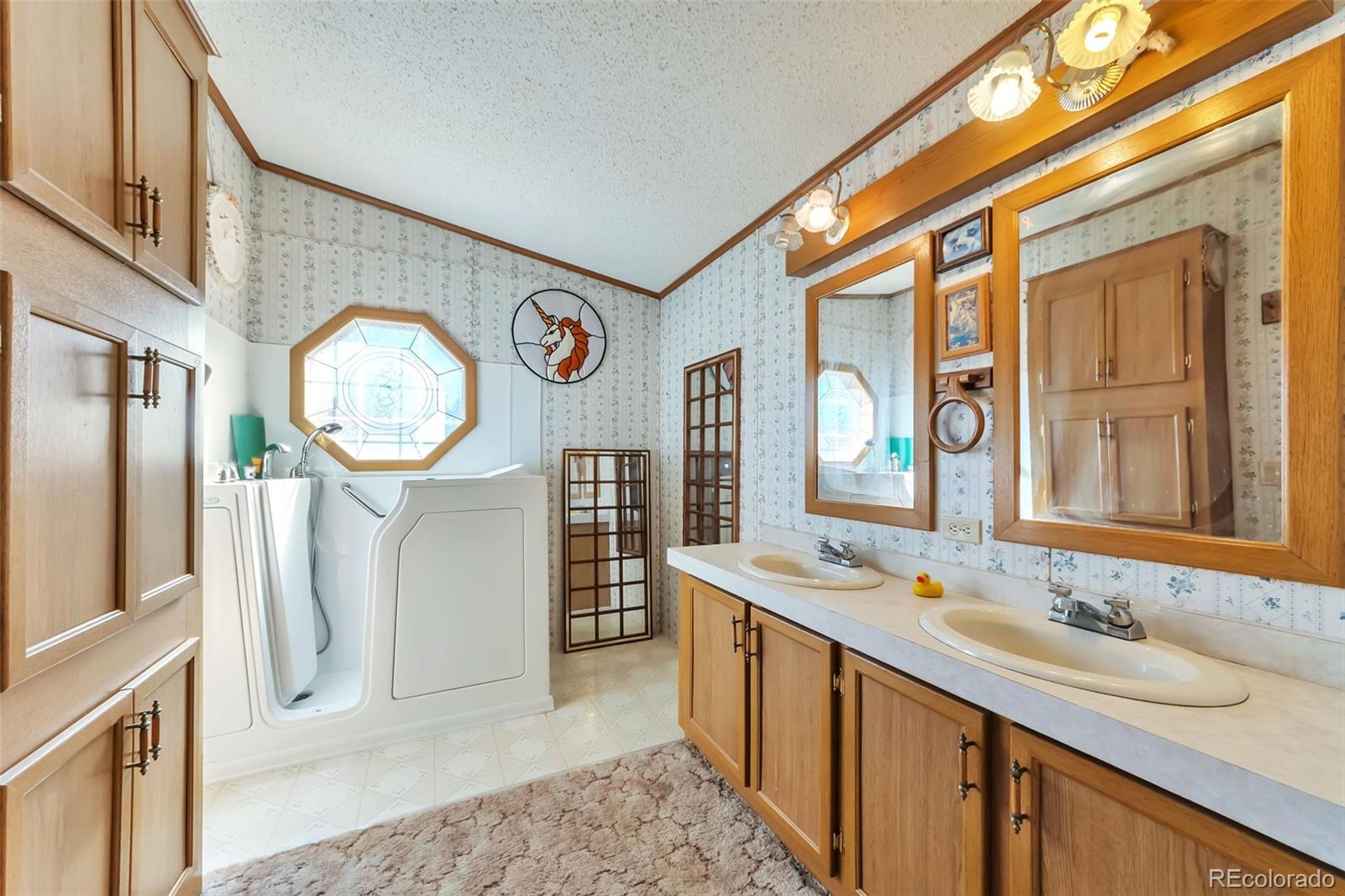 7702 Hart Street Fort Lupton, CO 80621 - Photo 12 of 25 a bathroom with a sink a mirror and a shower