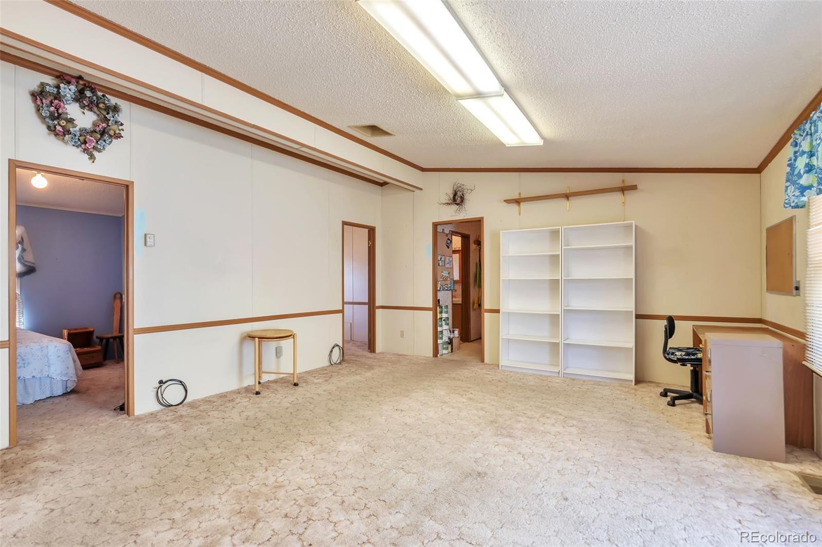 7702 Hart Street Fort Lupton, CO 80621 - Photo 14 of 25 a view of a livingroom with wooden furniture and windows