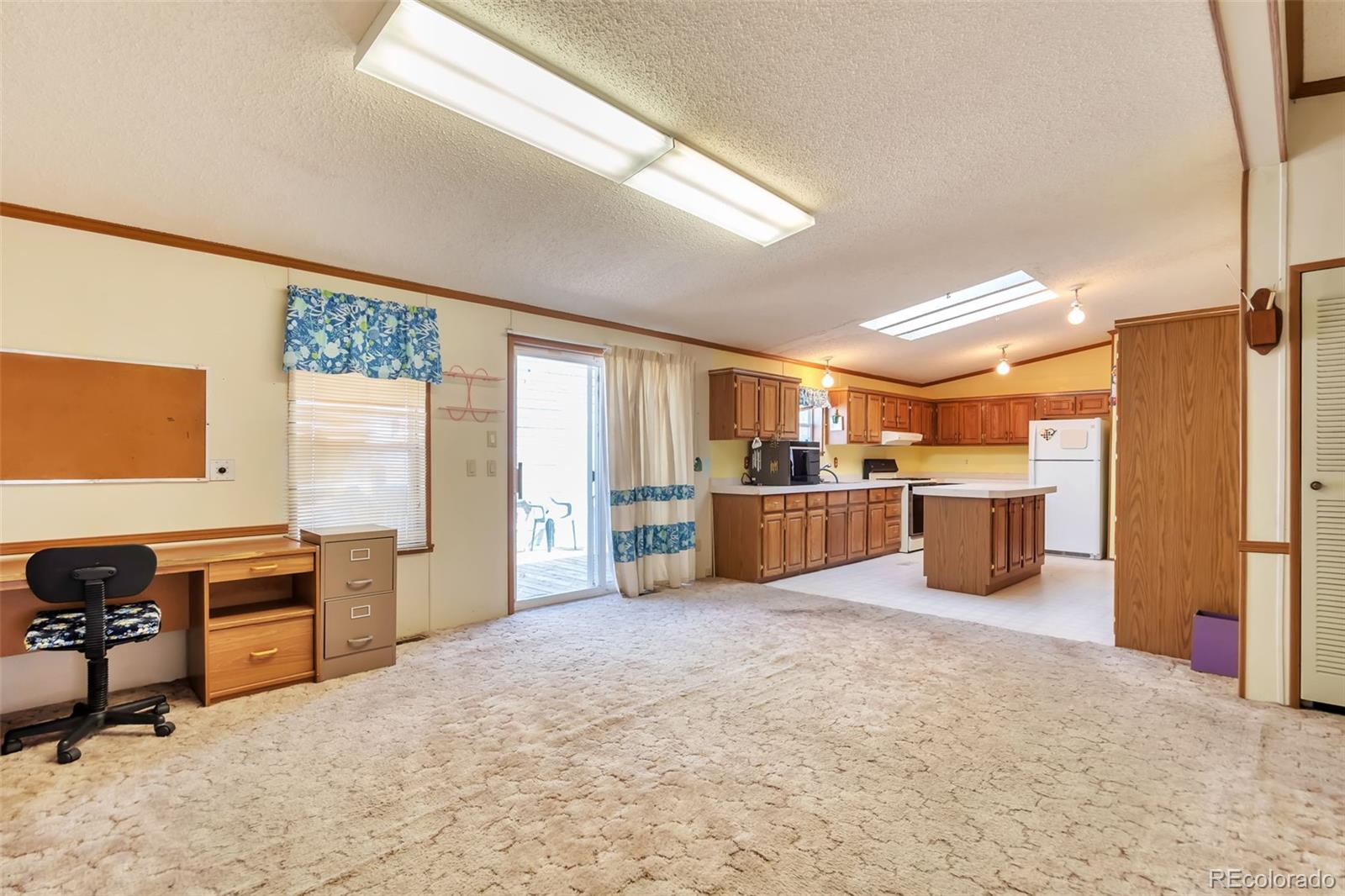 7702 Hart Street Fort Lupton, CO 80621 - Photo 15 of 25 a large kitchen with stainless steel appliances a stove a sink a refrigerator and cabinets