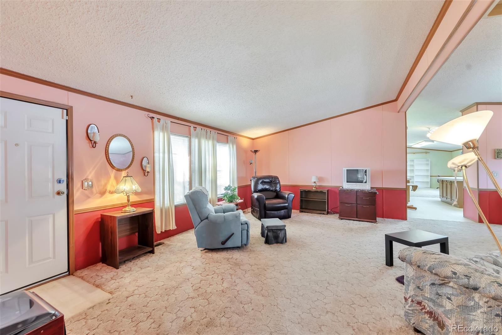 7702 Hart Street Fort Lupton, CO 80621 - Photo 6 of 25 a living room with furniture kitchen view and a large window