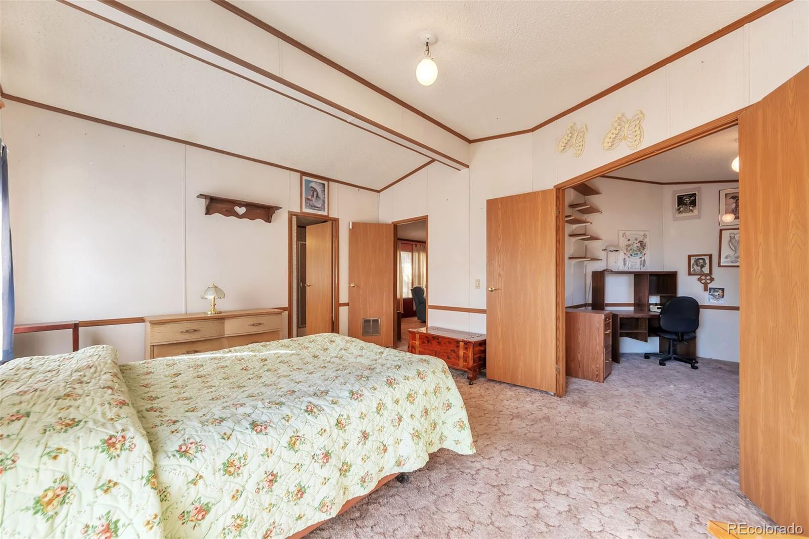 7702 Hart Street Fort Lupton, CO 80621 - Photo 10 of 25 a bedroom with a bed and a view of bathroom