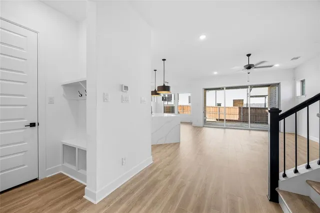a view of a hallway with wooden floor and staircase