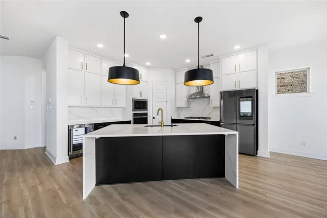 a view of a kitchen with wooden floor and a ceiling fan