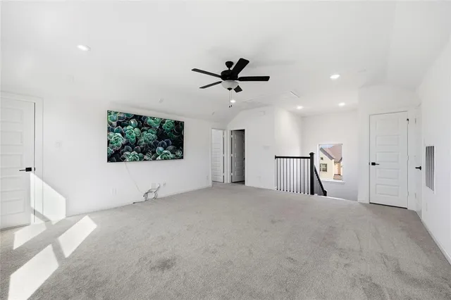 an empty room with windows and ceiling fan