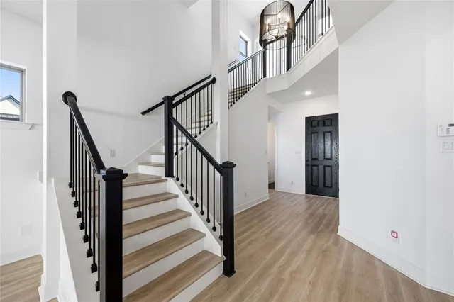a view of staircase with railing and white walls