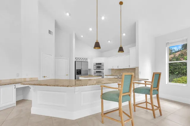 a kitchen with stainless steel appliances granite countertop a sink and a large window