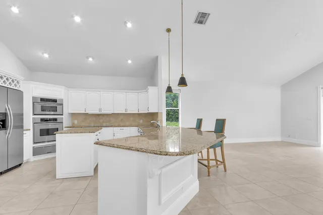 an empty room with floor to ceiling window and an outdoor view