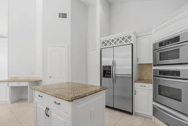 an empty room with wooden cabinet and windows