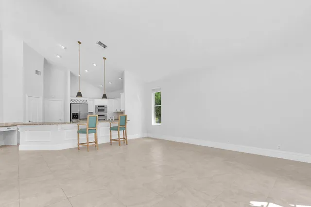 an empty room with windows and ceiling fan