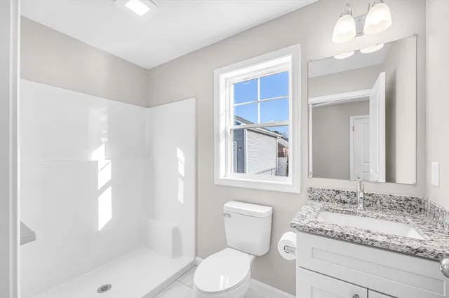 a bathroom with a granite countertop sink toilet and shower