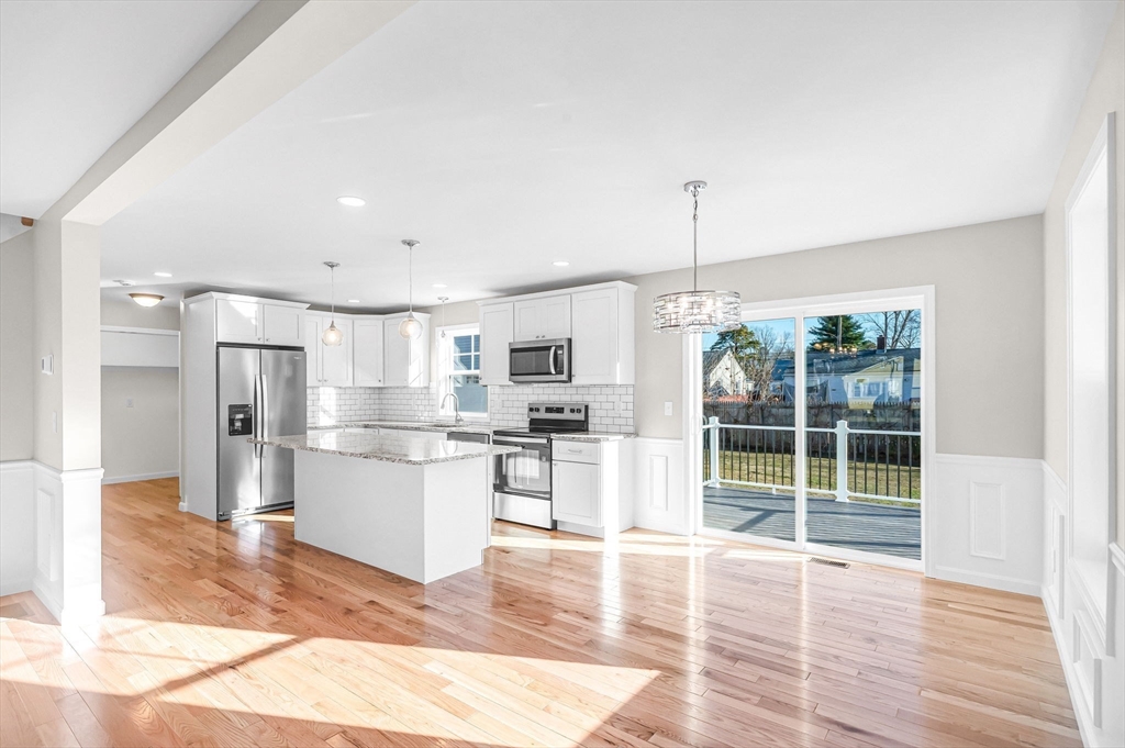 39 Wallace Street Springfield, MA 01119 - Photo 10 of 41 a open kitchen with stainless steel appliances granite countertop a refrigerator oven a sink dishwasher and white cabinets with wooden floor