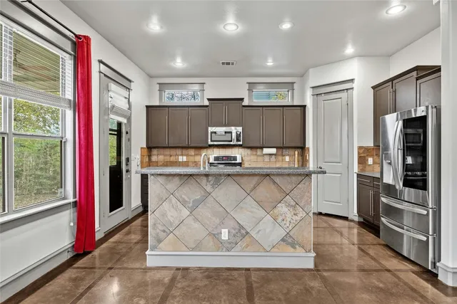 a kitchen with stainless steel appliances granite countertop a refrigerator and a stove
