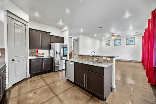 a kitchen with stainless steel appliances a sink a stove a refrigerator and cabinets