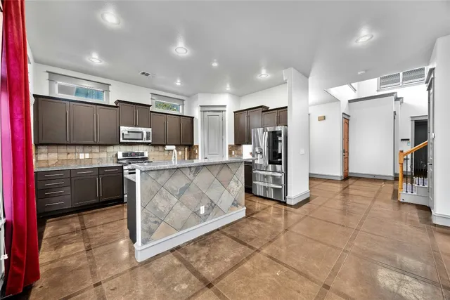 a kitchen with stainless steel appliances a refrigerator sink and microwave
