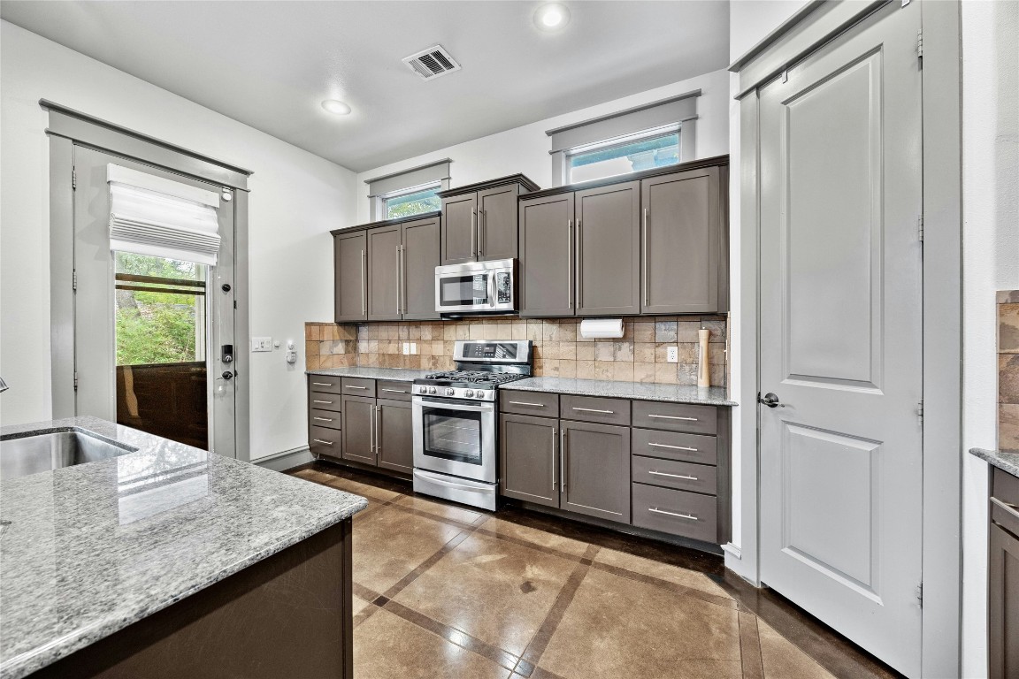 5617 Clay Avenue, Unit B Austin, TX 78756 - Photo 14 of 38 a kitchen with kitchen island granite countertop a stove refrigerator and sink