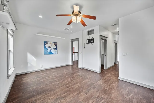 a view of a livingroom with wooden floor ceiling fan