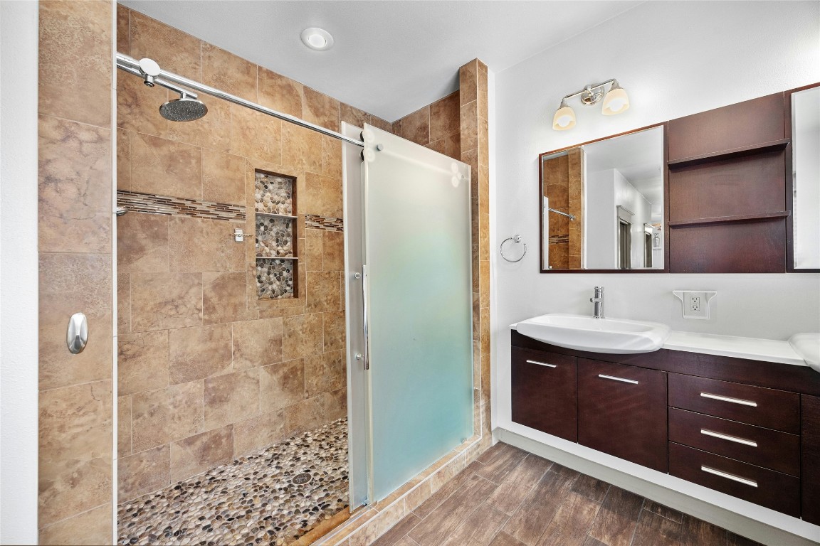 5617 Clay Avenue, Unit B Austin, TX 78756 - Photo 25 of 38 a bathroom with a double vanity sink a large mirror and shower