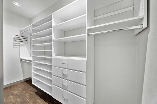 a view of walk in closet with empty racks