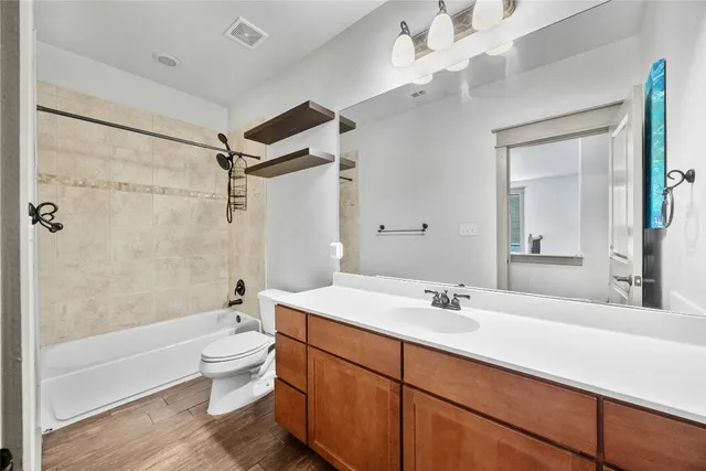 a bathroom with a sink a toilet a mirror a bathtub and shower