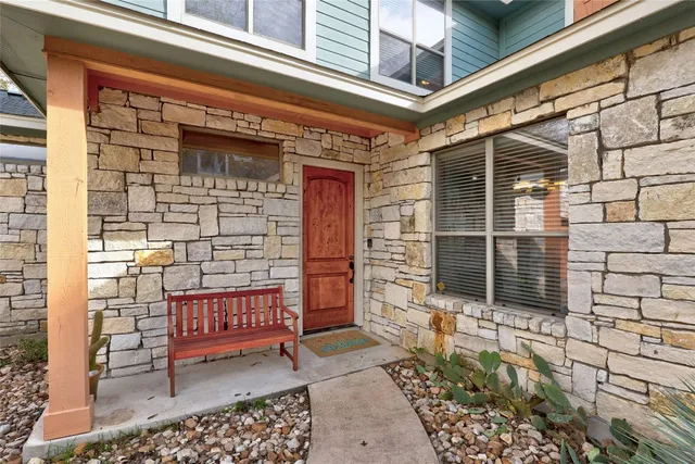 a view of a door with a chair and table and potted plants