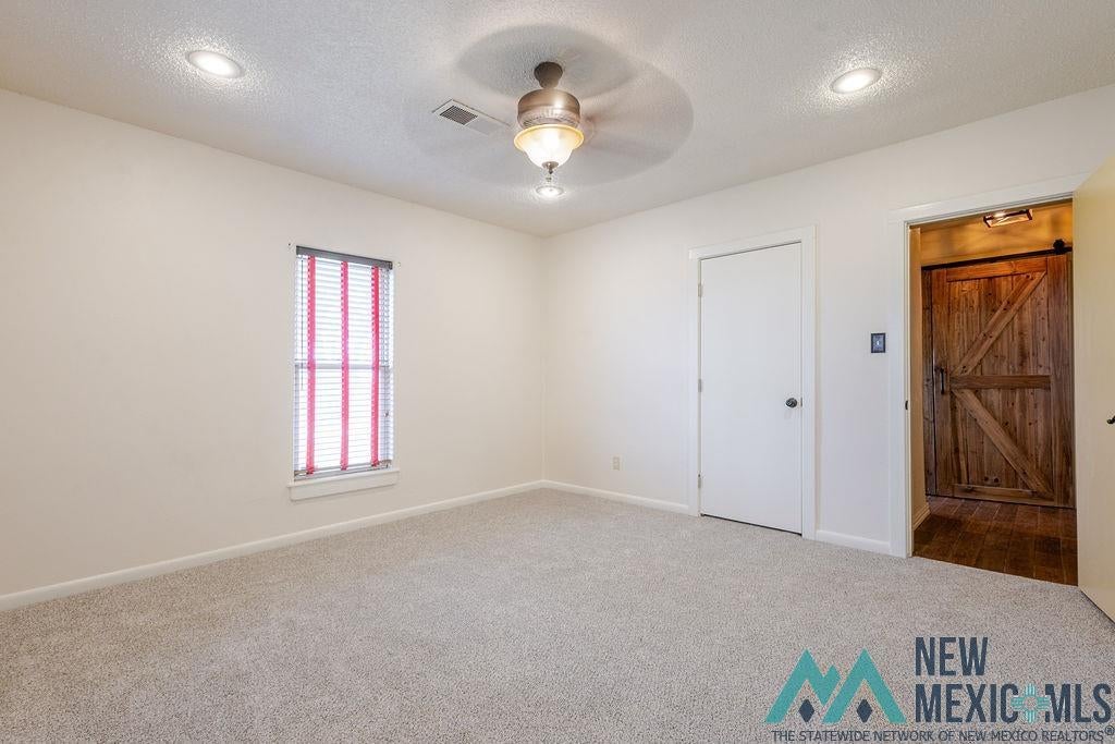 1131 Curry Road North Clovis, NM 88101 - Photo 33 of 69 Spacious room featuring neutral carpeting, recessed lighting, a ceiling fan with light, and a window with blinds