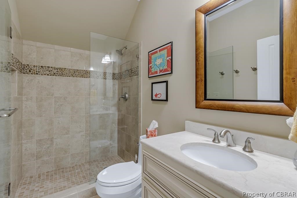 2055 Ditchley Road Kilmarnock, VA 22482 - Photo 34 of 48 Bathroom with tiled shower, vanity with extensive cabinet space, and toilet