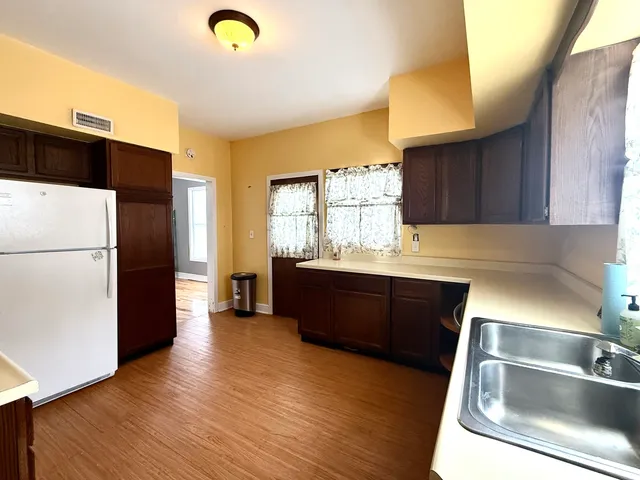 a kitchen with stainless steel appliances granite countertop a refrigerator a sink dishwasher a stove with wooden floor