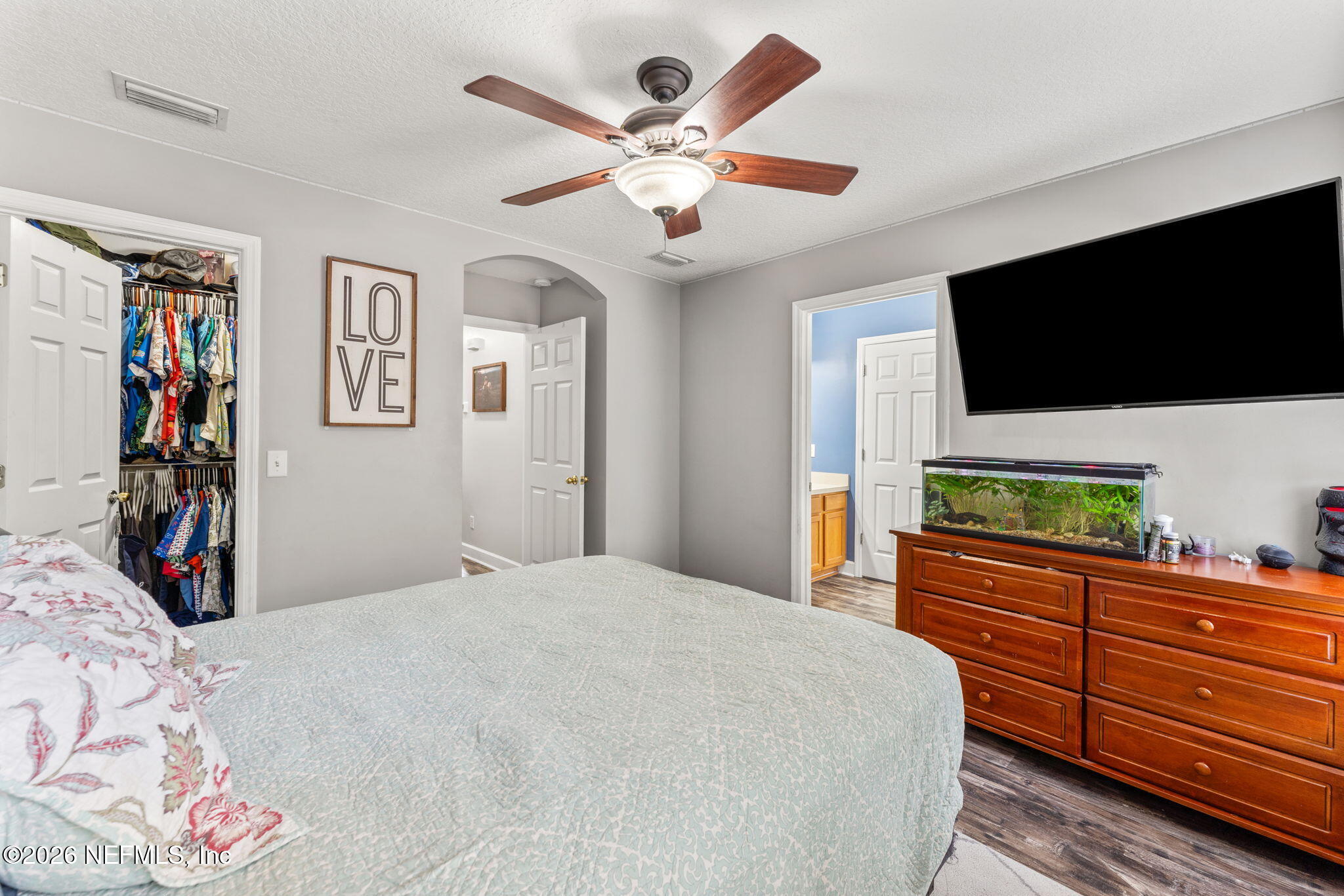 482 North 3rd Street Macclenny, FL 32063 - Photo 14 of 32 a bedroom with a large bed a flat tv screen and dresser