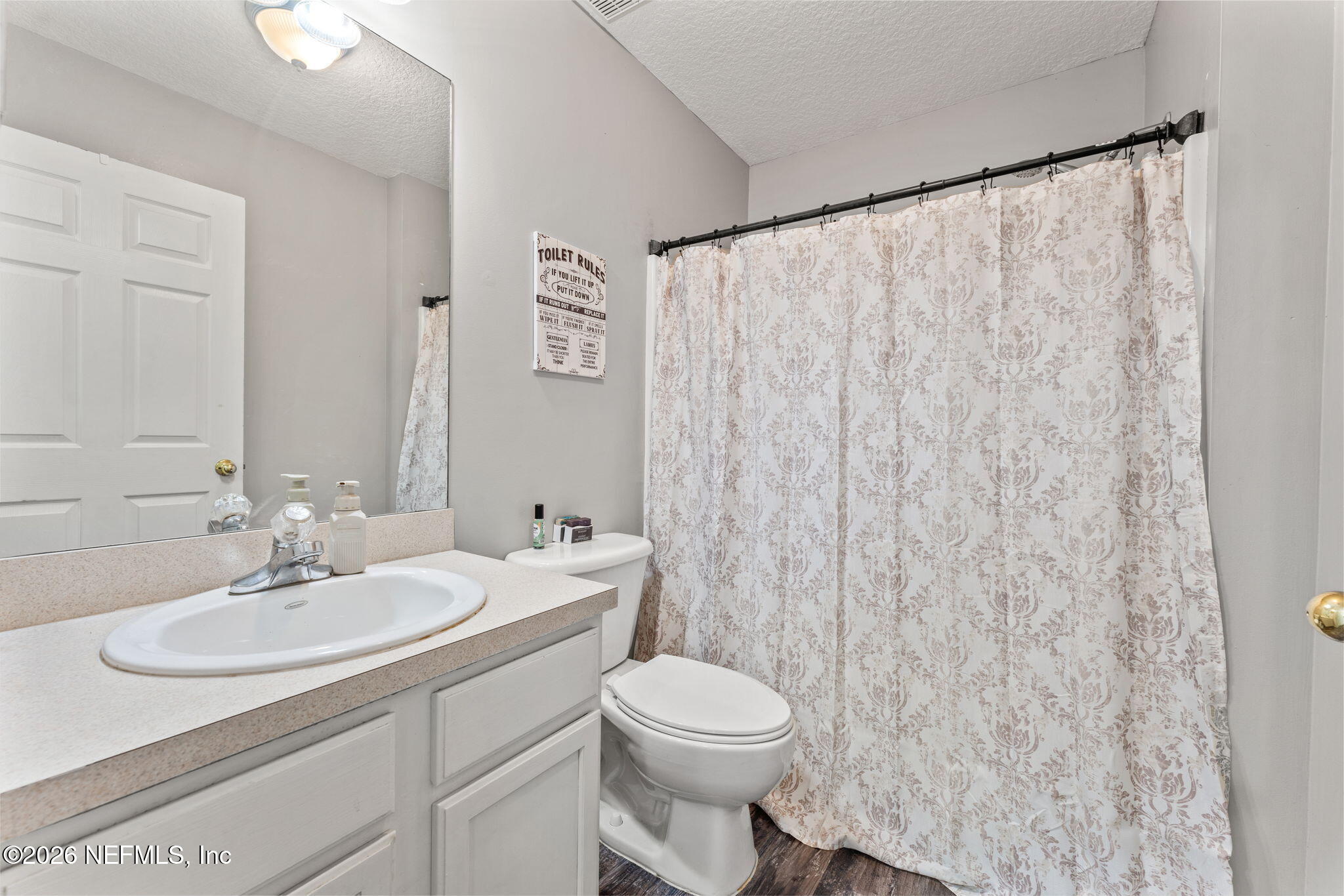482 North 3rd Street Macclenny, FL 32063 - Photo 20 of 32 a bathroom with a sink a toilet and a mirror