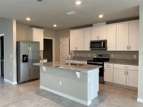 a kitchen with stainless steel appliances a refrigerator stove microwave and sink