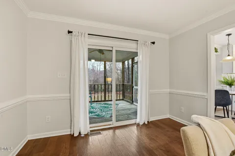 a kitchen with stainless steel appliances granite countertop a stove a refrigerator a sink a dining table and chairs with wooden floor