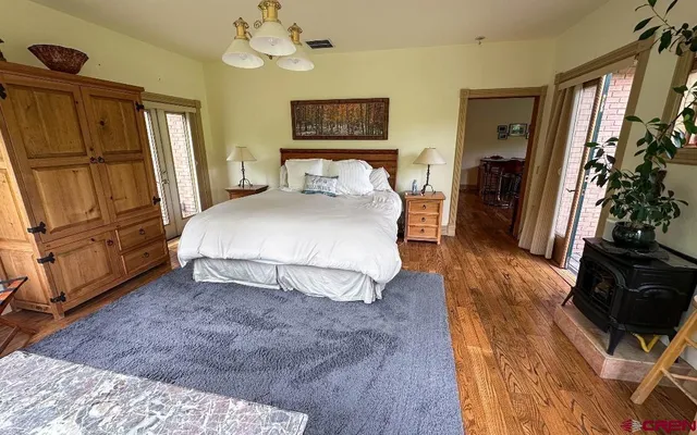 a spacious bedroom with a bed dresser and a flat tv screen