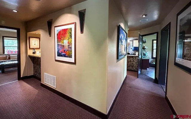 a view of a hallway with furniture and wooden floor