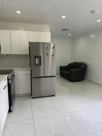 a kitchen with a refrigerator and a stove top oven