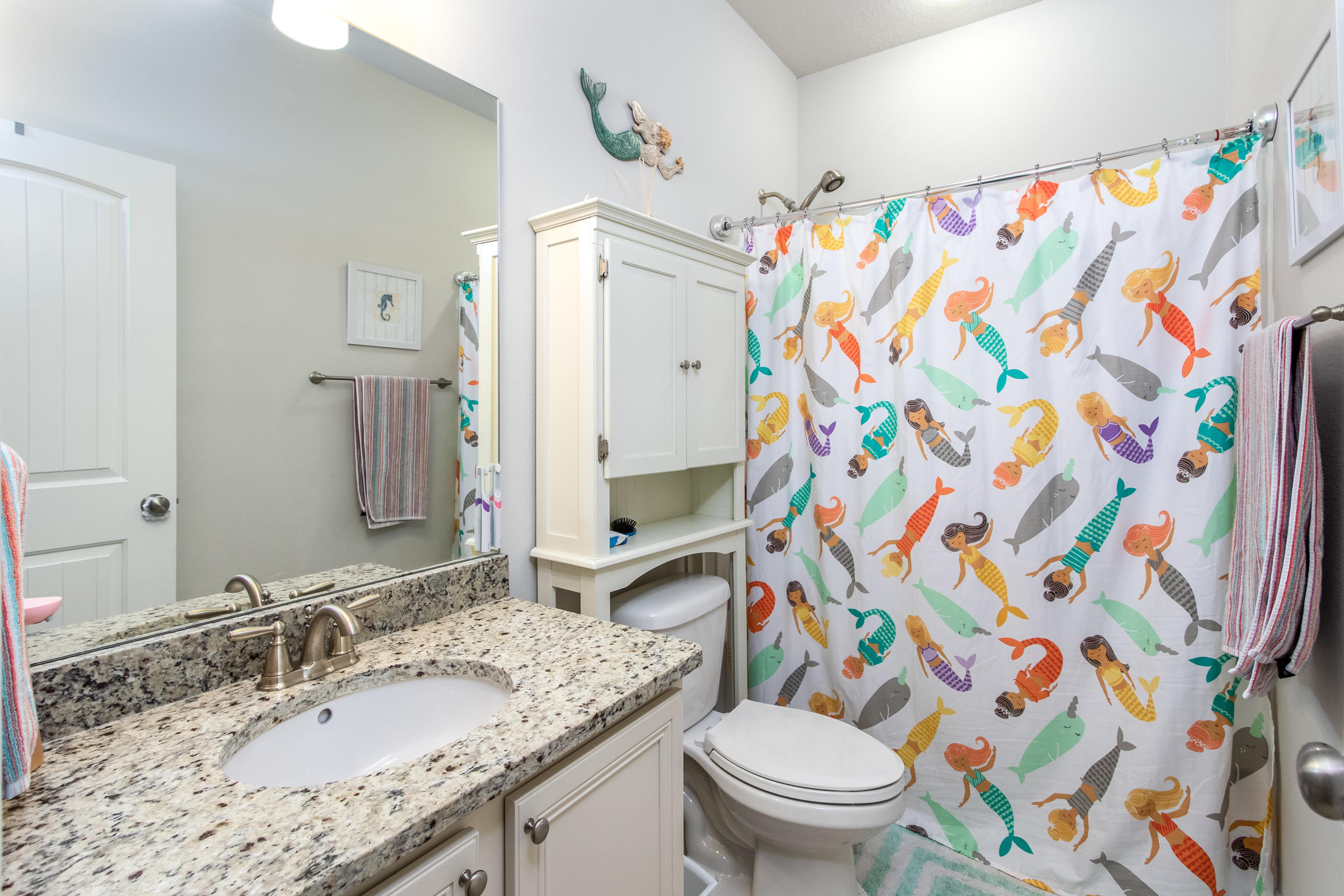 196 Pin Oak Loop Santa Rosa Beach, FL 32459 - Photo 19 of 34 a bathroom with a granite countertop toilet sink and a shower curtain
