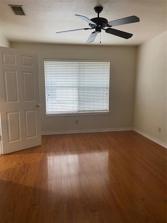 1102 North Main Street Leonard, TX 75452 - Photo 12 of 25 an empty room with wooden floor chandelier fan and windows
