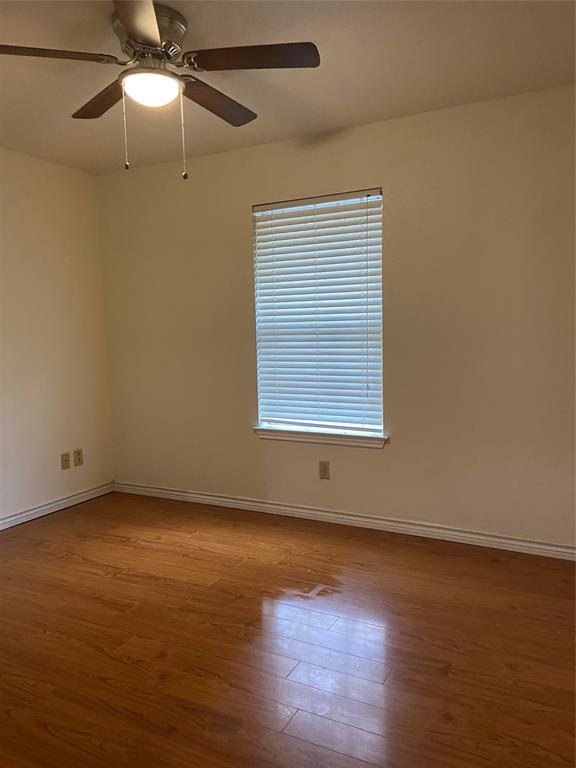 1102 North Main Street Leonard, TX 75452 - Photo 17 of 25 an empty room with wooden floor fan and windows