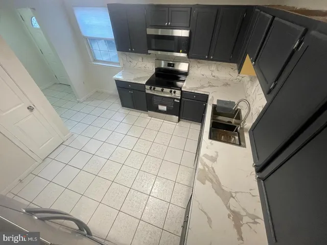 a kitchen with granite countertop a stove and a refrigerator