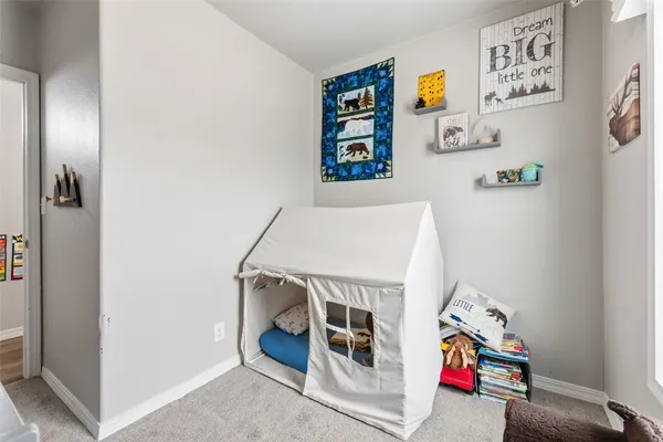 a utility room with fridge and rack