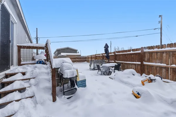 a view of a house with wooden stairs and a small yard