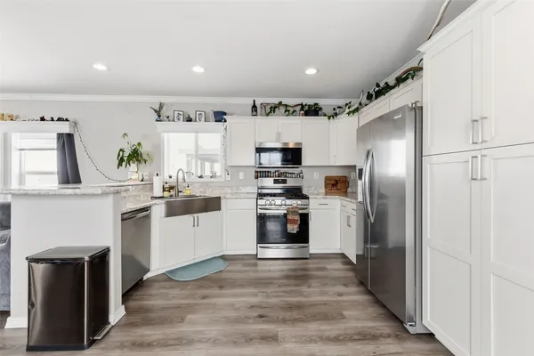 a kitchen with white cabinets and stainless steel appliances