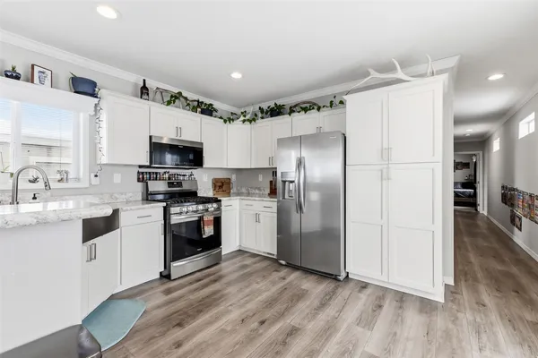 a kitchen with stainless steel appliances a refrigerator sink and microwave