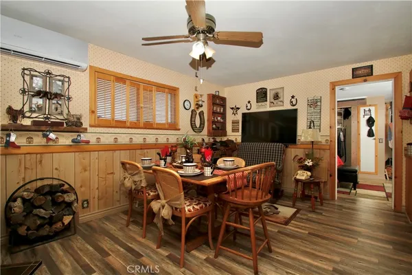 a kitchen with stainless steel appliances a dining table chairs and wooden floor
