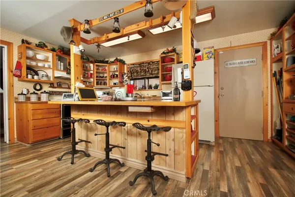 a kitchen with a stove and a wooden floor