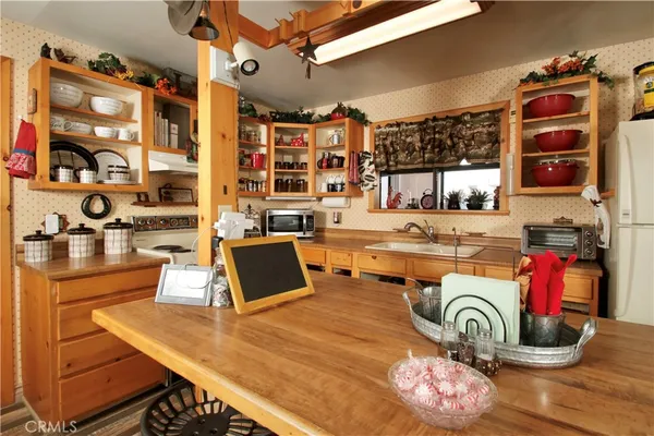 a kitchen with granite countertop a stove a sink and a wooden cabinets