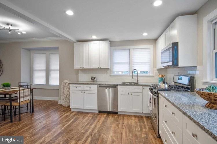14 Sewell Street Glassboro, NJ 08028 - Photo 8 of 15 a kitchen with stainless steel appliances granite countertop wooden cabinets a sink a stove a dining table and chairs